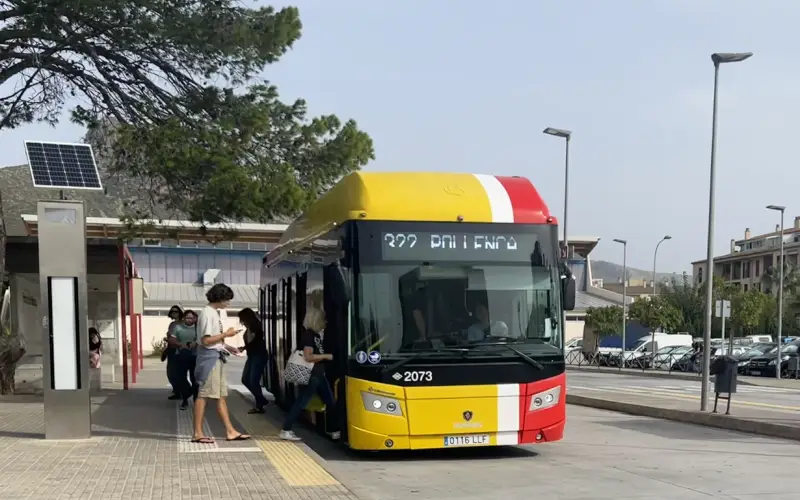 People boarding the 322 bus parked at the bus stop in the centre of Puerto Pollensa.