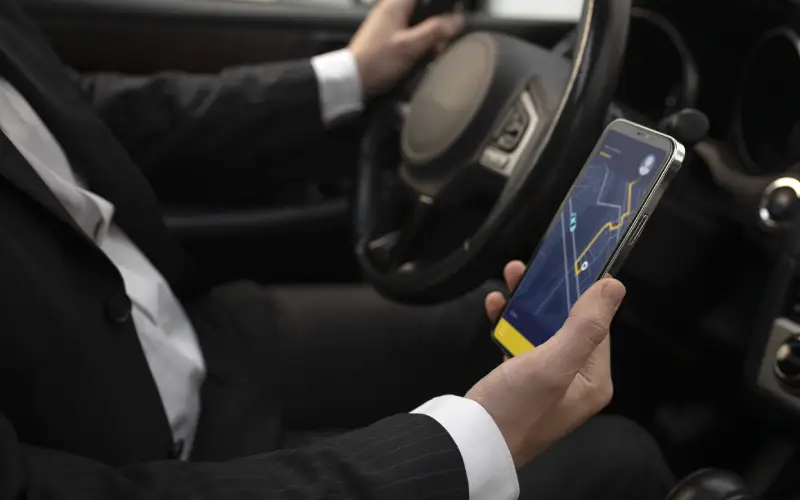 Transfer driver checking the route on his mobile phone before departure