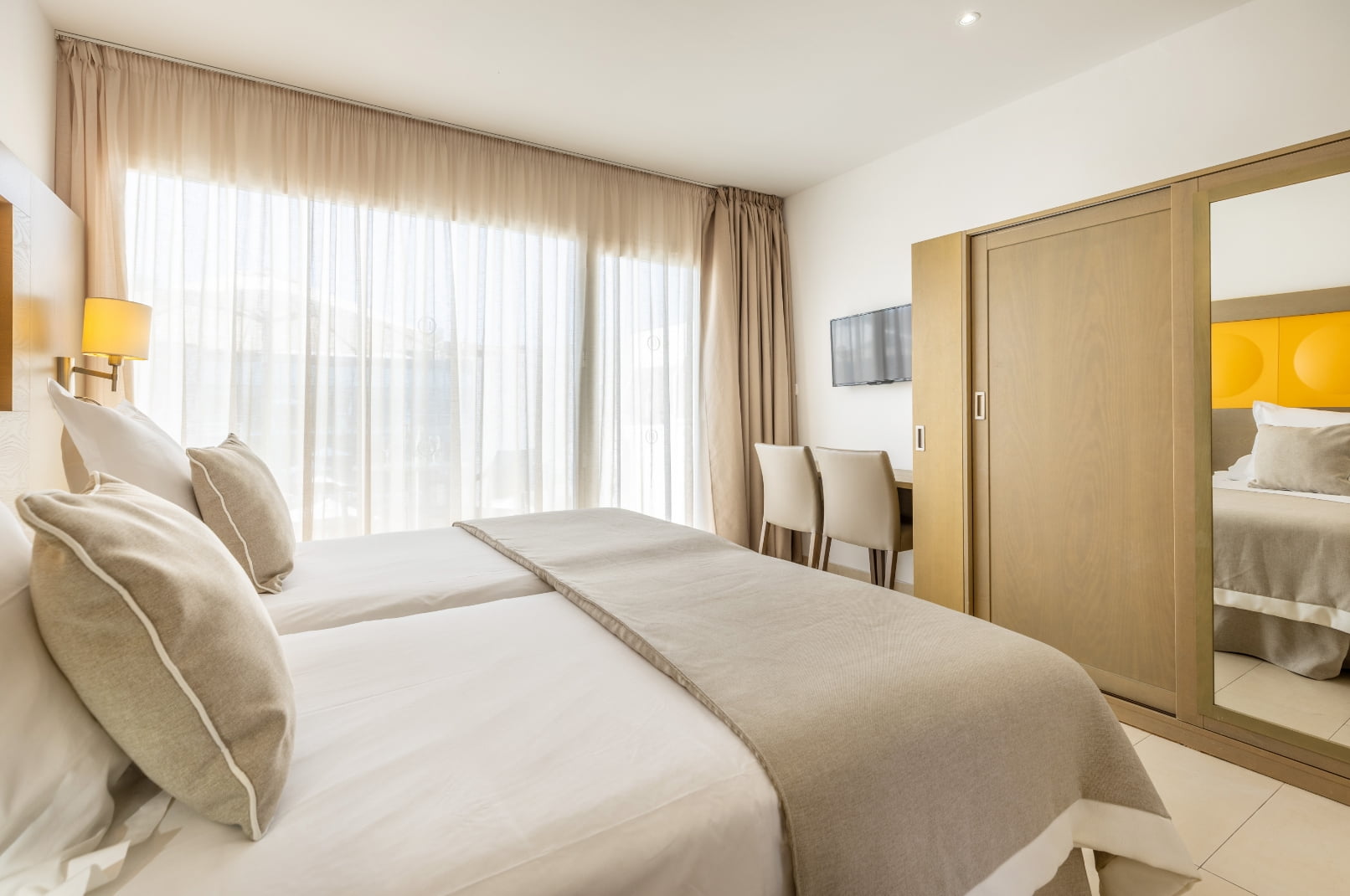 Cama doble frente a un amplio armario con espejo Estudio 6