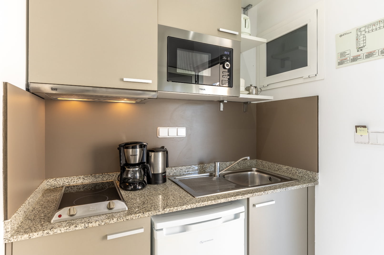 Detalle de la zona de cocina, equipada con cafetera, microondas, nevera y fogones Estudio 7